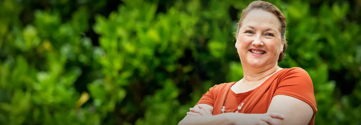 A smiling woman with arms folded